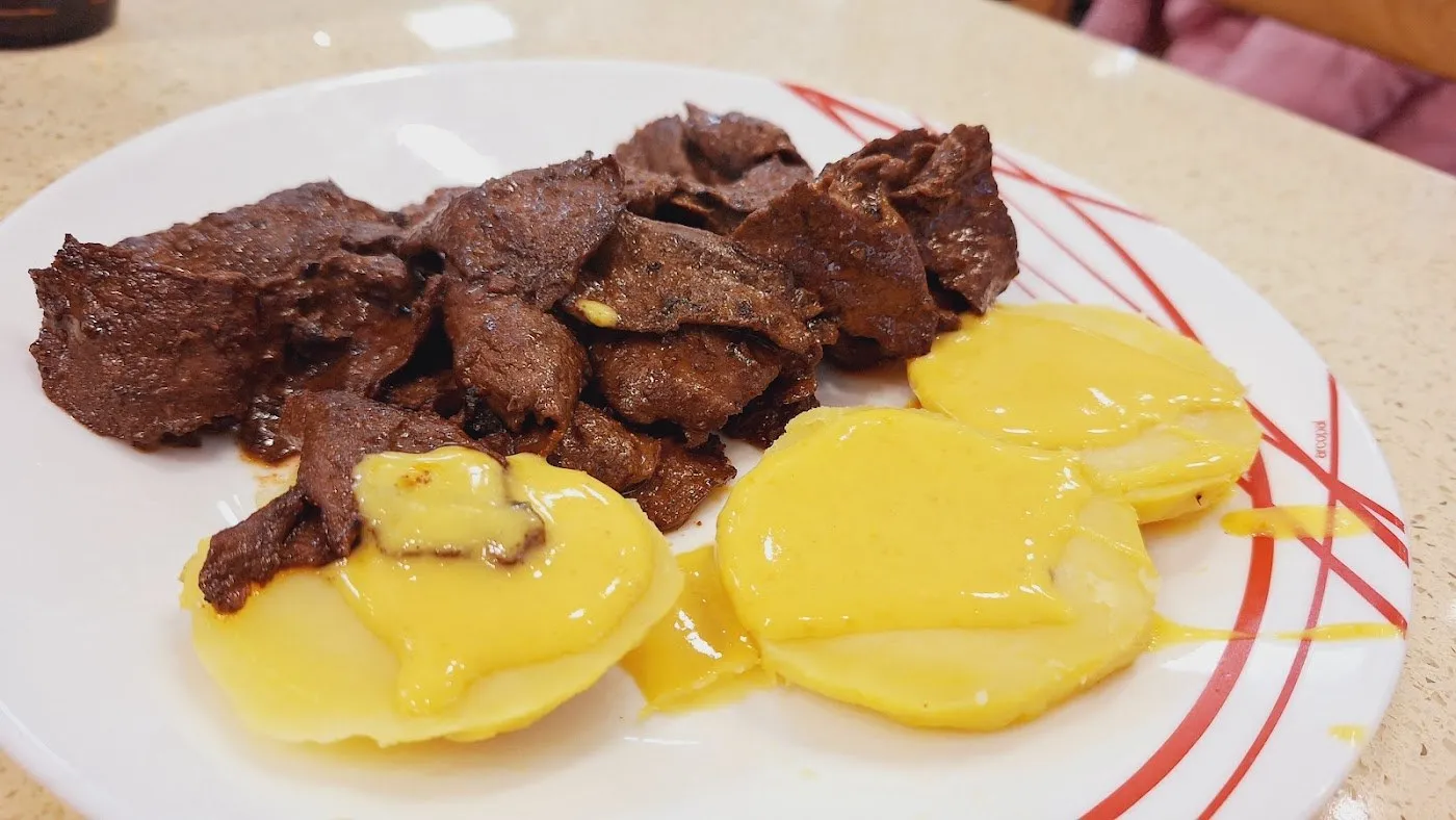 Anticuchos de corazón de ternera con rodajas de patata cocida y salsa amarilla
