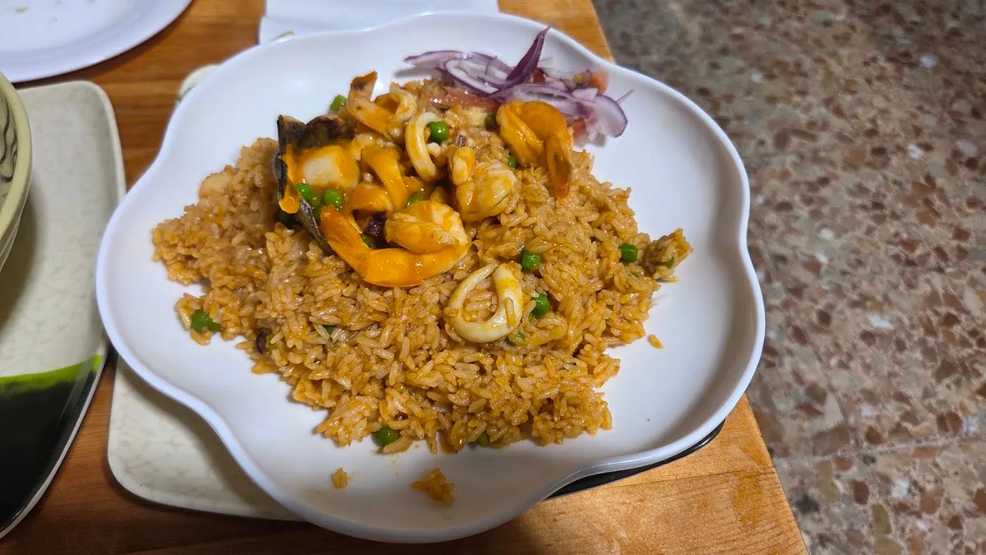 Arroz frito con mariscos y cebolla morada en un plato blanco