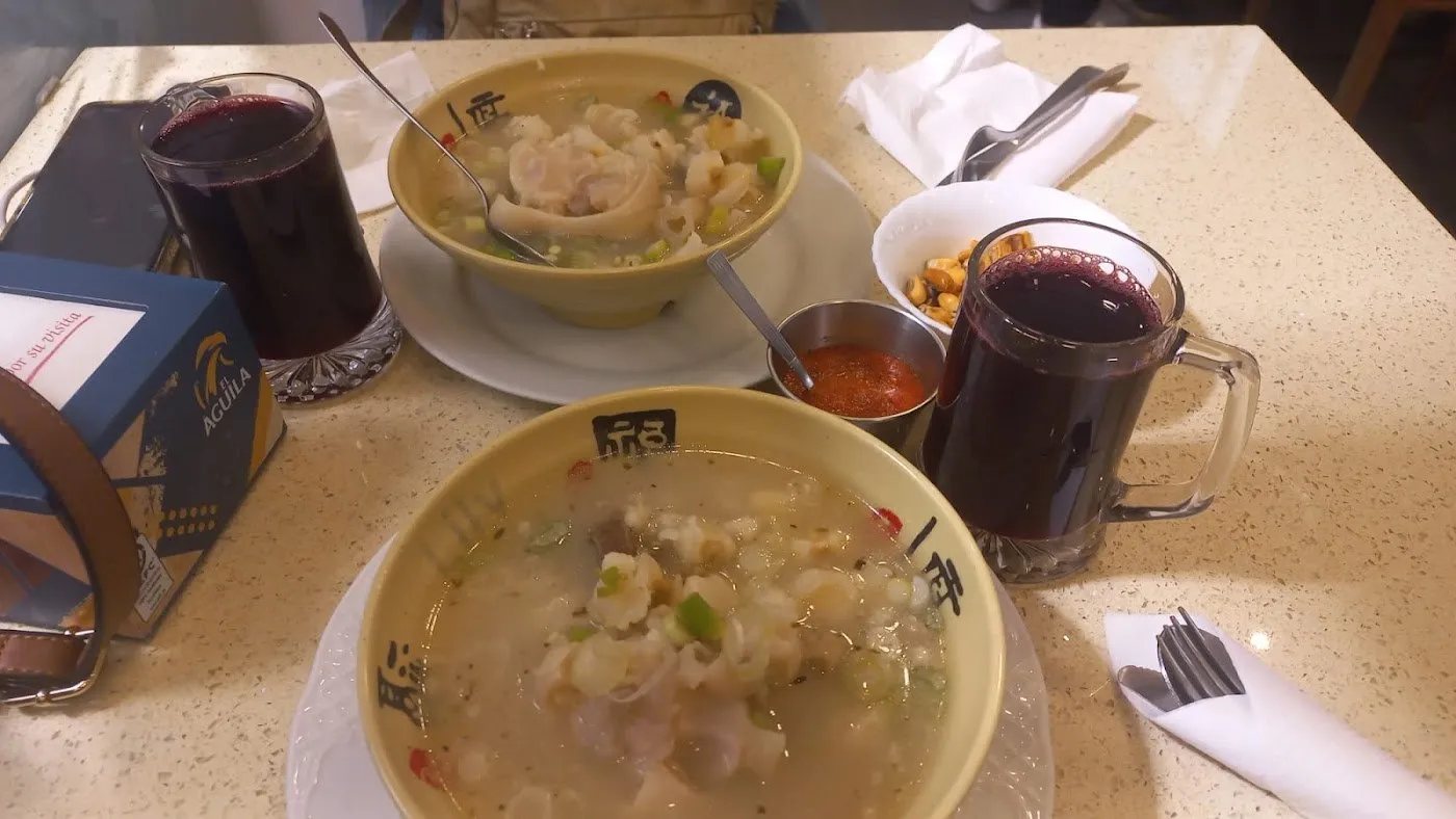 Dos cuencos de sopa wantán con dos vasos de chicha morada sobre la mesa